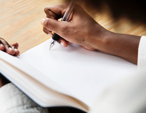 Woman's hands as she is writing in a notebook