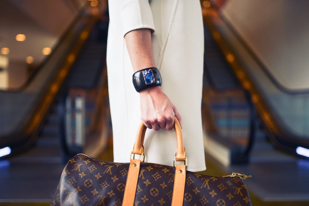 Woman's hand holding a Louis Vuitton bag