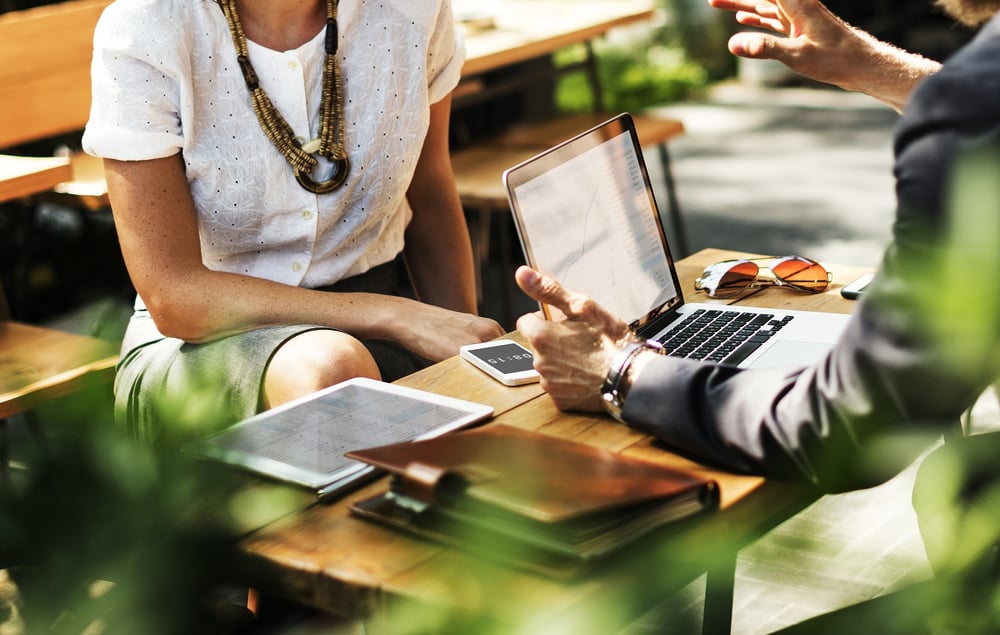 Woman and man having outdoor business meeting - heads are cropped out