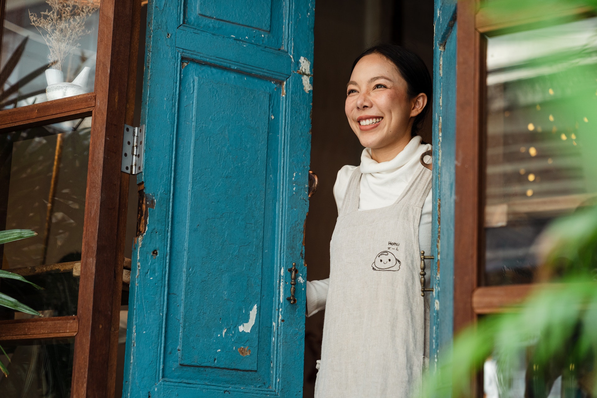 Small business owner standing in her doorway